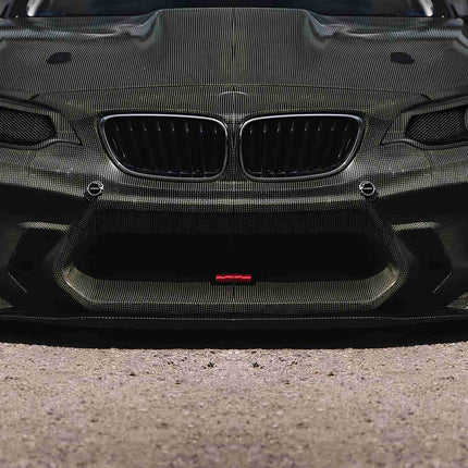 "Front view of a BMW M2 Competition, showcasing its black kidney grille, angular headlights, and muscular front bumper."
