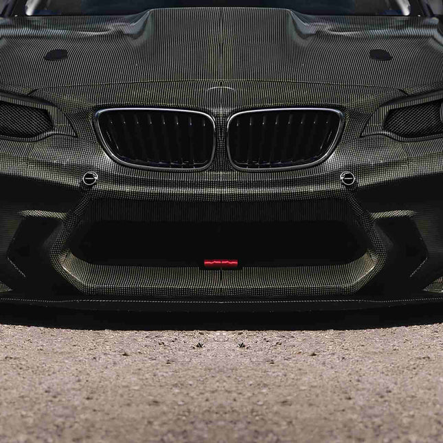 "Front view of a BMW M2 Competition, showcasing its black kidney grille, angular headlights, and muscular front bumper."