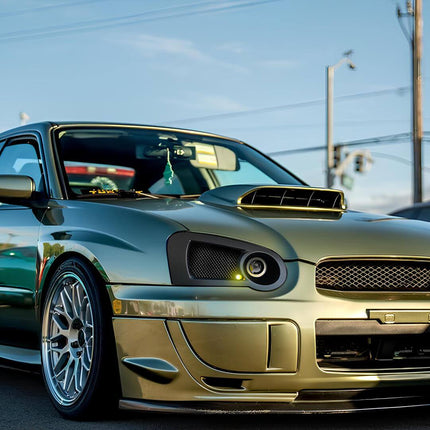Front three-quarter view of a 2003 Subaru Impreza WRX Wagon in Midnight Blue Pearl, showcasing the functional roof rails and spacious cargo area, combining performance with versatility for active lifestyles.

