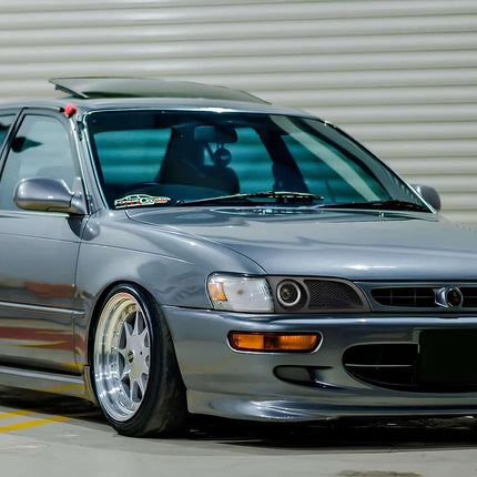 AE100 turbo manifold, stainless steel equal-length design, optimized exhaust gas velocity, improved turbo spool efficiency, race-spec high-performance forced induction upgrade.

