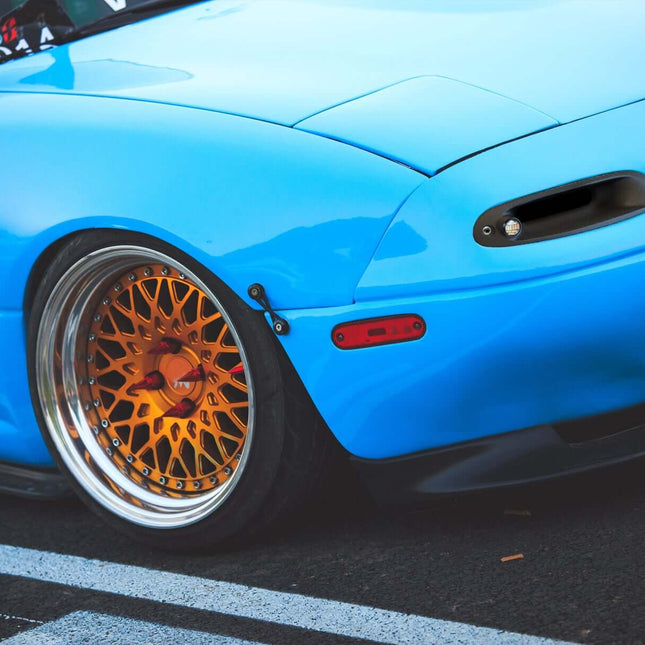 Mazda Miata MX-5 NA Roadster full aero body kit, JDM-style front bumper, carbon fiber rear diffuser, side skirts, vented hood, aggressive styling, track-optimized aerodynamics, lightweight racing body panels.

