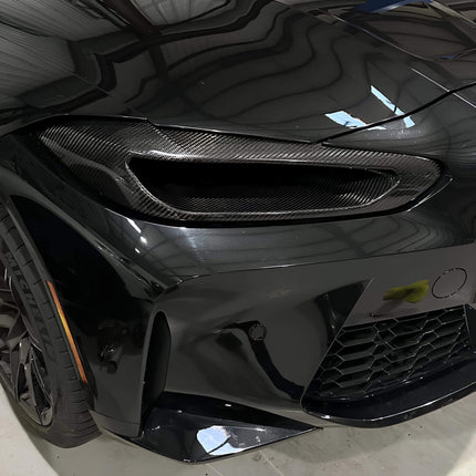 Close-up of the BMW G82 M4's carbon-fiber roof, emphasizing weight-saving measures and lowered center of gravity, contributing to enhanced handling and performance dynamics on both road and track.