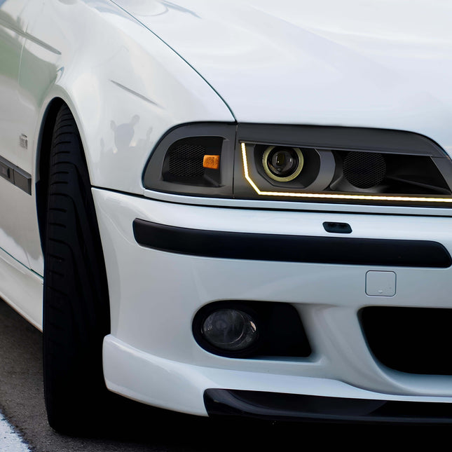 A well-maintained BMW E39 530i with its hood open at a car meet, revealing the legendary M54 inline-six engine, known for its durability and smooth power delivery.

