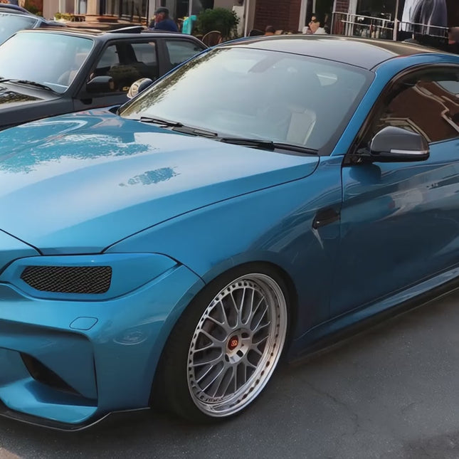 "A BMW 2 Series coupe (F22) in motion, showcasing its sporty and compact design with aggressive body lines."